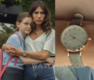 Evin Ahmad wears a round gold watch green strap in the Netflix series Who is Erin Carter?