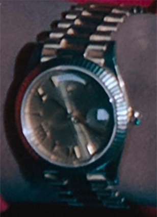 The gold Rolex Day-Date watch worn by Jerrod Carmichael in Rothaniel has Roman Numerals on the dial.