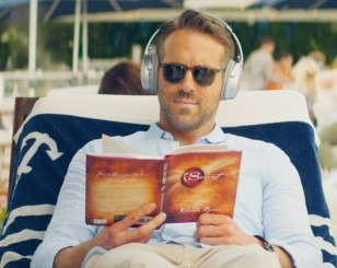 Ryan Reynolds is reading the book The Secret by Rhonda Byrne, and wears yet unidentified sunglasses.